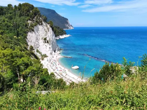 Le splendide spiagge del Conero, con la loro sabbia bianca e il mare cristallino, incorniciate da scogliere a picco e vegetazione lussureggiante.