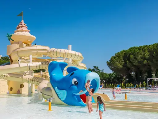 Un parco acquatico con scivoli a forma di castello e balena blu, ideale per campeggi in Toscana sul mare per bambini.