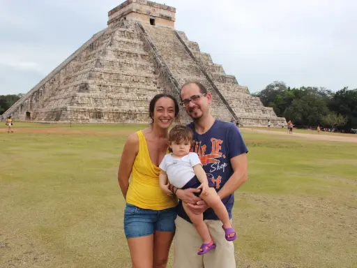 Famiglia felice in vacanza in Messico con bambini, davanti alla piramide di Chichen Itza.