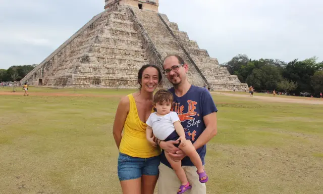 Famiglia felice in vacanza in Messico con bambini, davanti alla piramide di Chichen Itza.