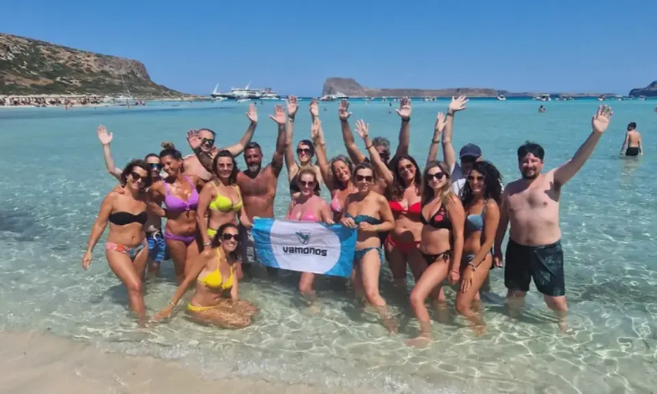 Un gruppo di amici festeggia in mare, con le braccia alzate, in una giornata di sole. Sembra proprio che festa è Ferragosto!