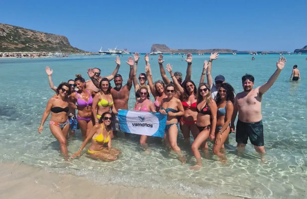 Un gruppo di amici festeggia in mare, con le braccia alzate, in una giornata di sole. Sembra proprio che festa è Ferragosto!