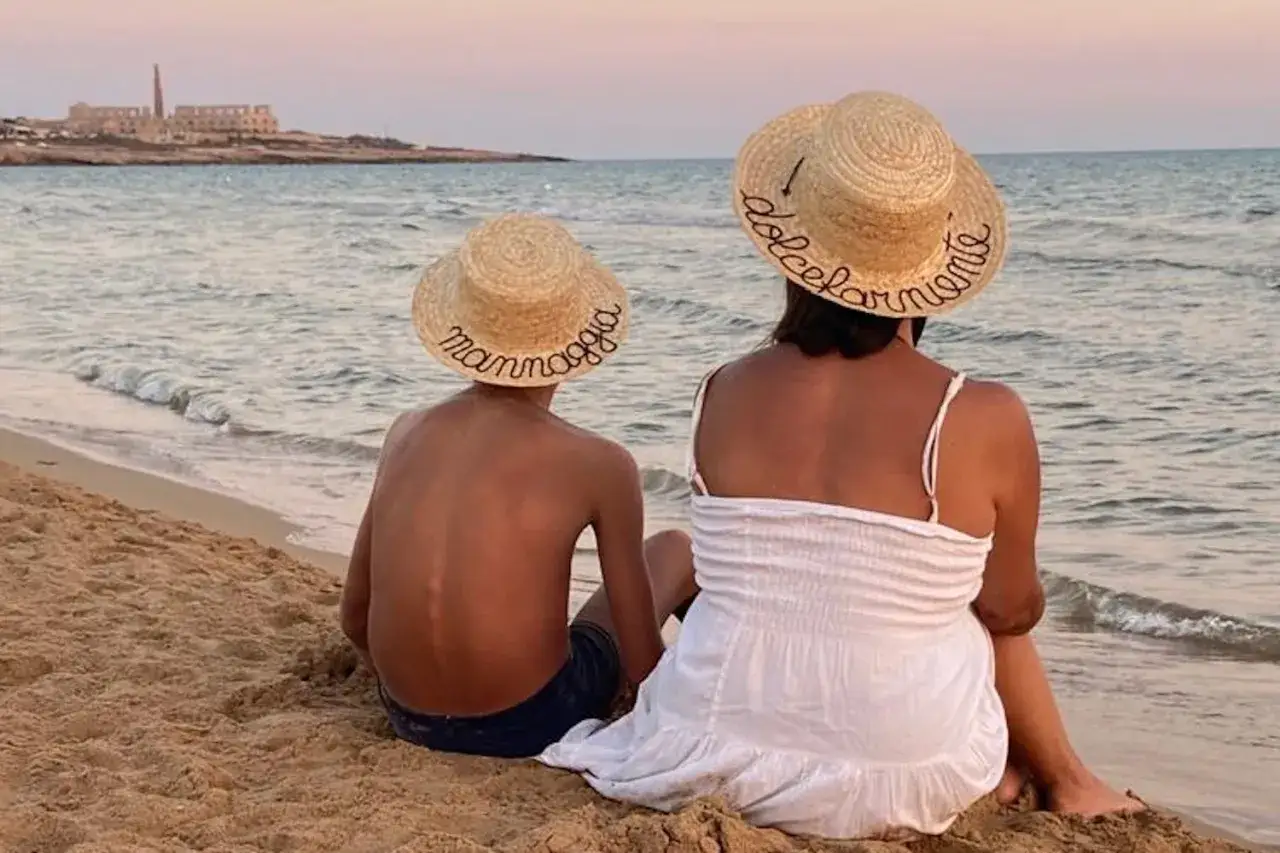 Mom and son in Sicilia con bambini, con cappelli di paglia che recitano 