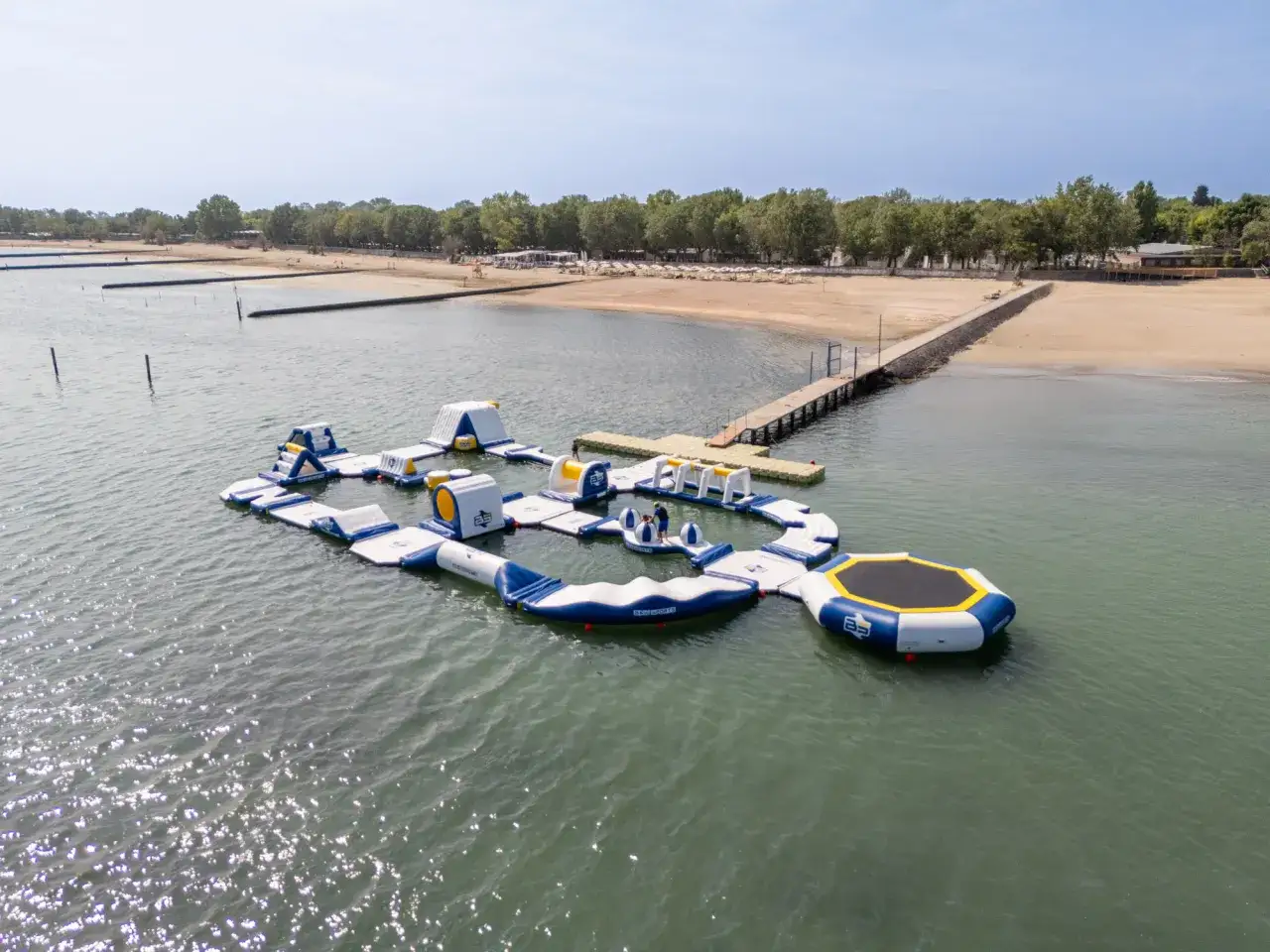 Parco acquatico gonfiabile al Falkensteiner Family Resort Lido, con scivoli, trampolini e percorsi per divertirsi in acqua.