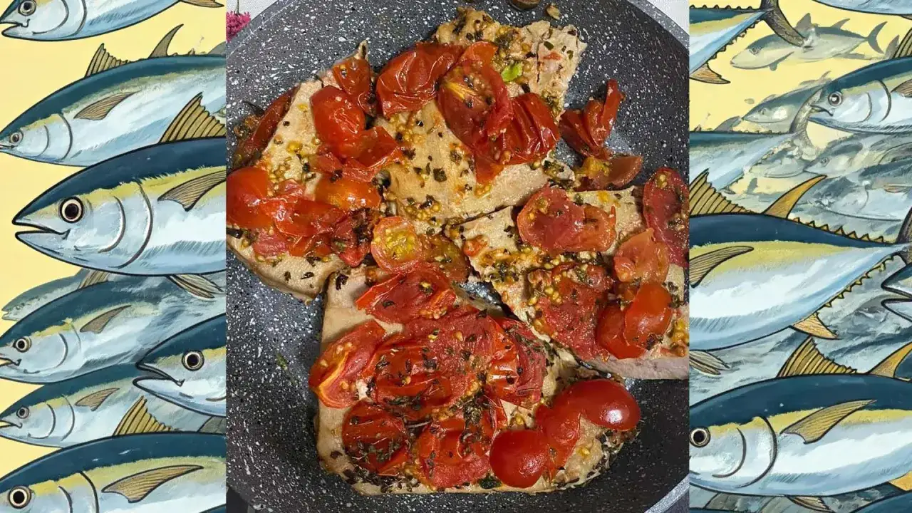 Bistecche di specie di tonno cotte in padella con pomodorini e erbe aromatiche, circondate da illustrazioni di tonni.