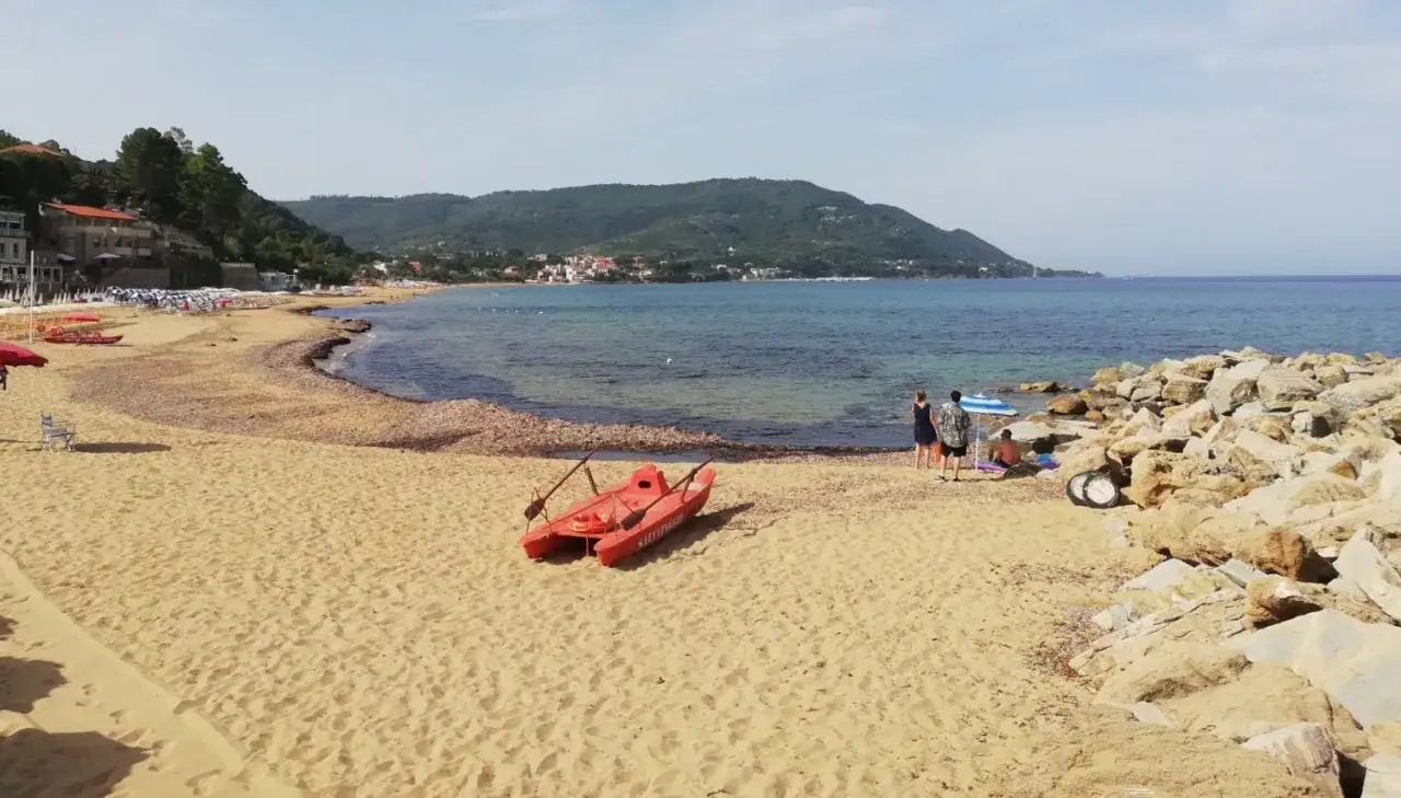 Spiagge del Cilento ideali per bambini: sabbia dorata, mare calmo e un gommone rosso pronto per l'avventura.
