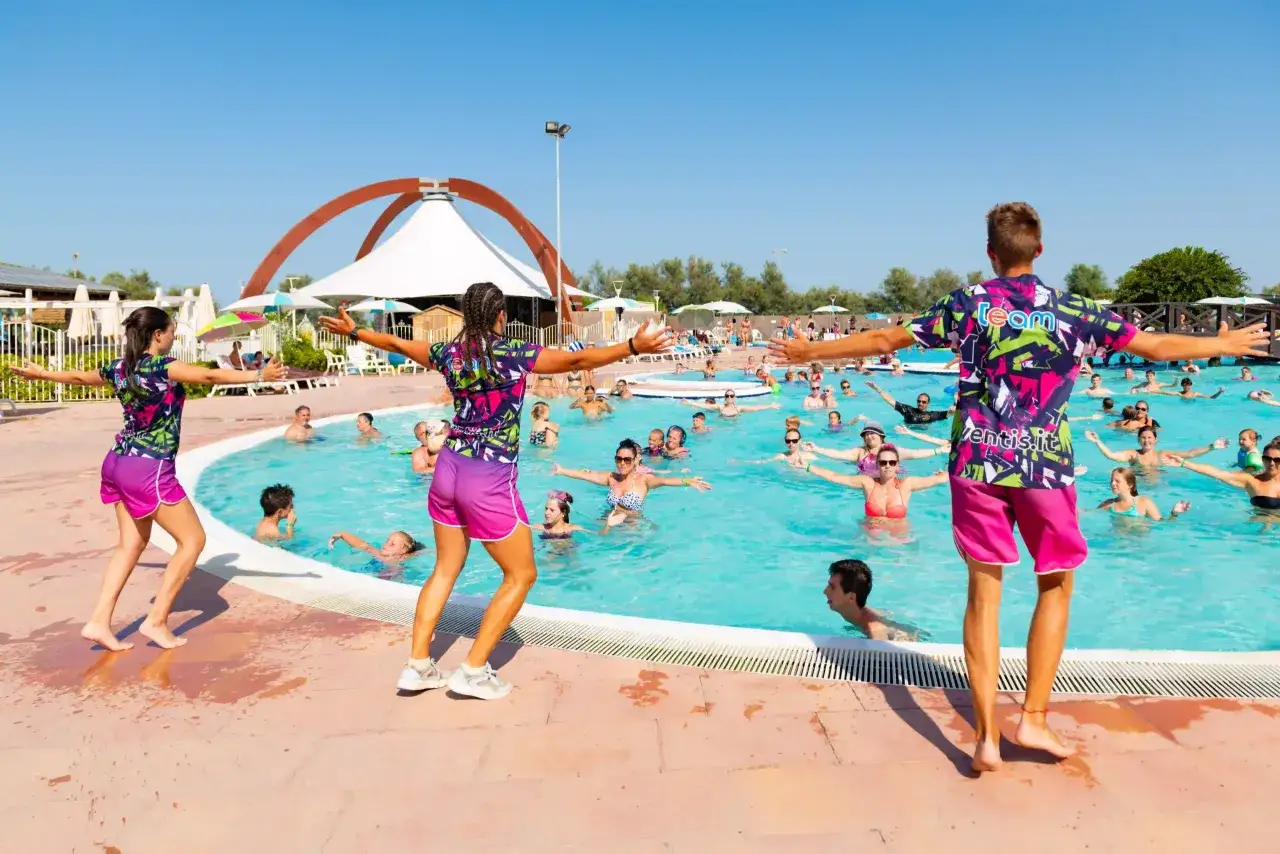 Animatori guidano un corso in piscina in uno dei campeggi toscana sul mare per bambini. Divertimento assicurato per tutta la famiglia!