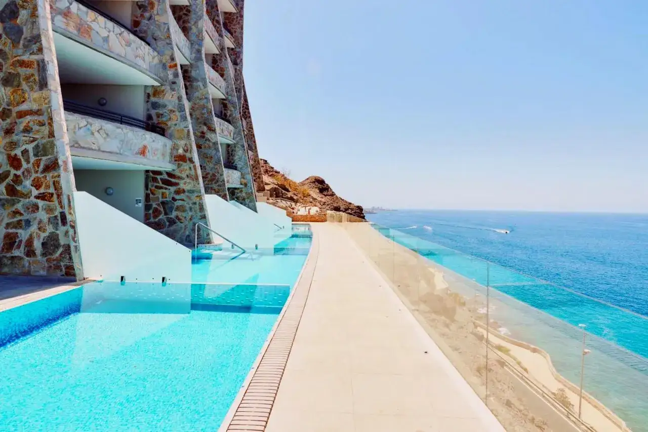 Piscina a sfioro con vista sull'oceano al searesort Riu Gran Canaria. Architettura moderna e mare blu intenso.