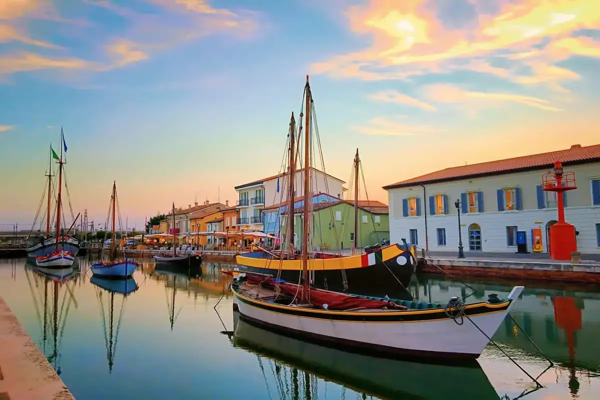Barche a vela ormeggiate nel porto canale di Cesenatico al tramonto. Un luogo incantevole per scoprire cosa fare a Cesenatico.