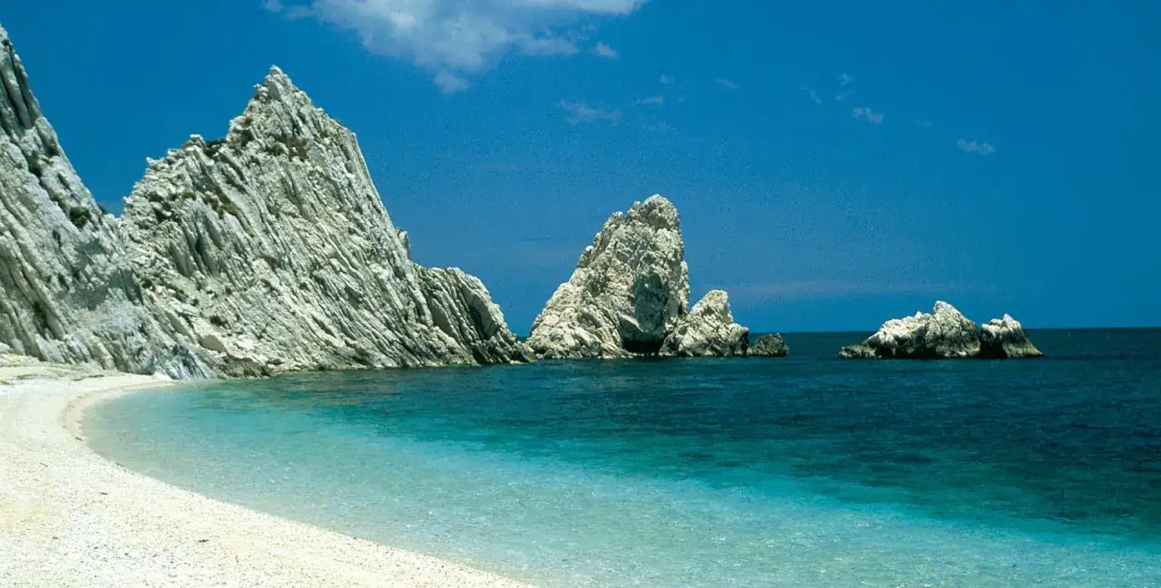 Spiaggia bianca e mare cristallino con faraglioni imponenti. Un angolo di paradiso per sapere dove andare al mare nelle Marche.