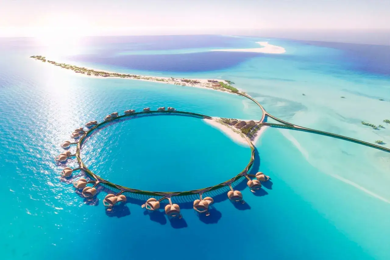 Resort circolare su palafitte nel Mar Rosso Arabia Saudita, con isole sabbiose e acque turchesi.