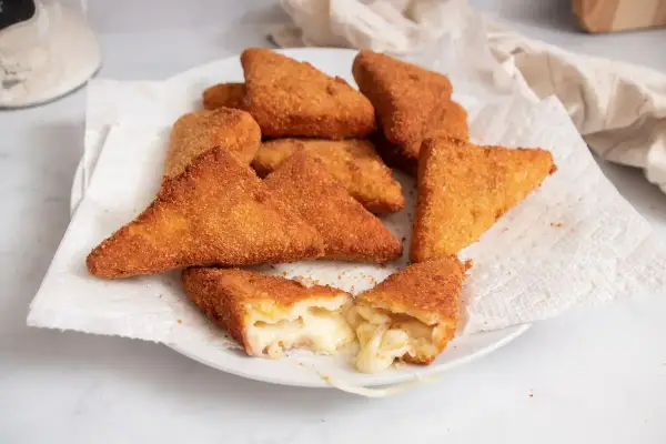 Mozzarella in carrozza dorate e croccanti, una fetta mostra il formaggio filante all'interno.